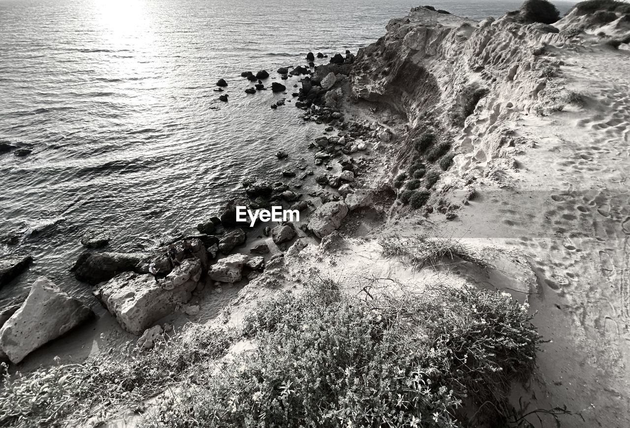 HIGH ANGLE VIEW OF ROCKS IN SEA