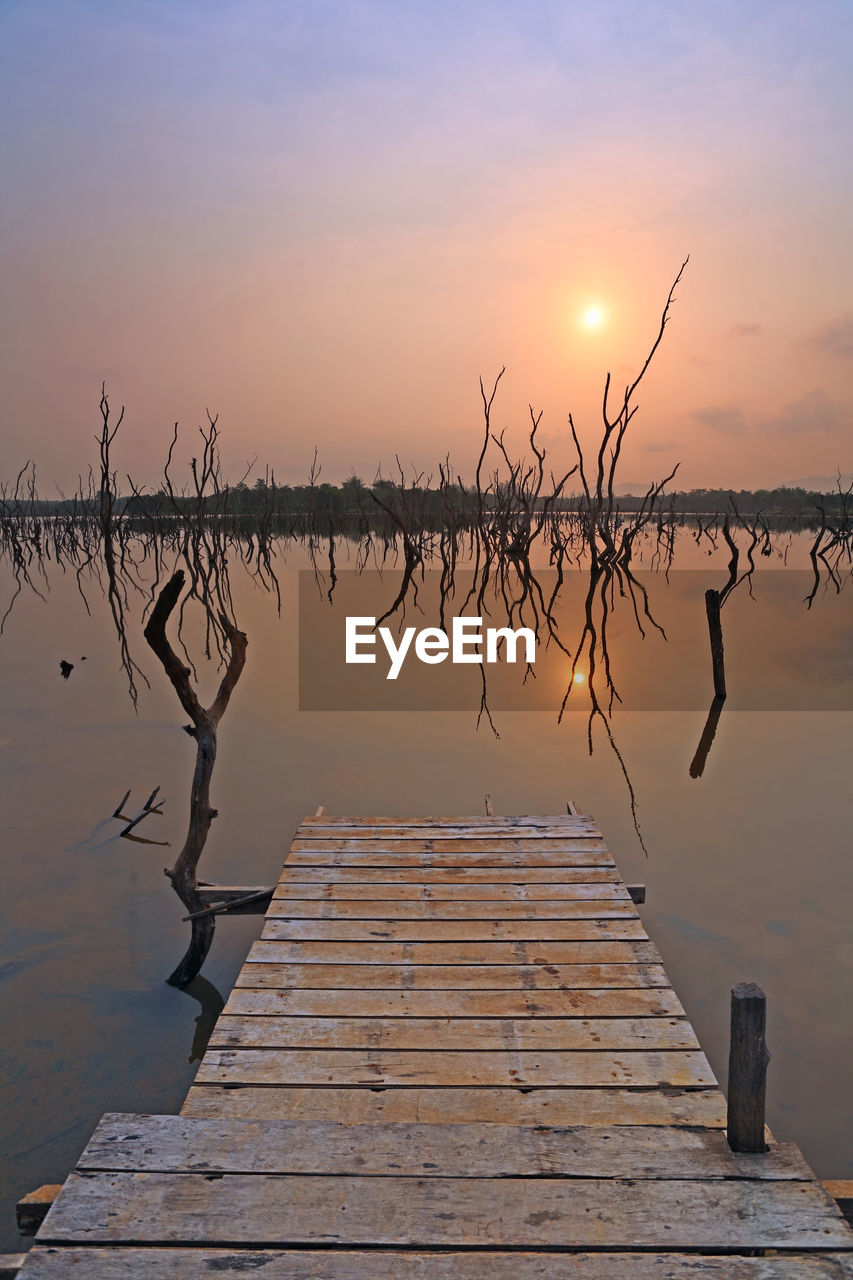 SCENIC VIEW OF PIER OVER LAKE AGAINST SKY DURING SUNSET