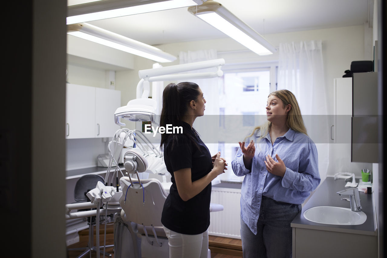 Female dentist talking to patient in office
