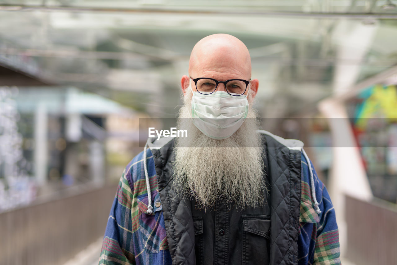 PORTRAIT OF MAN STANDING AGAINST GRAFFITI