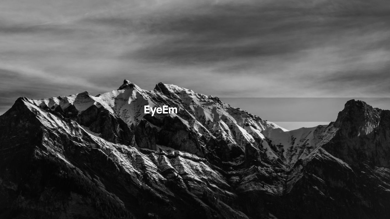 Scenic view of mountains against cloudy sky