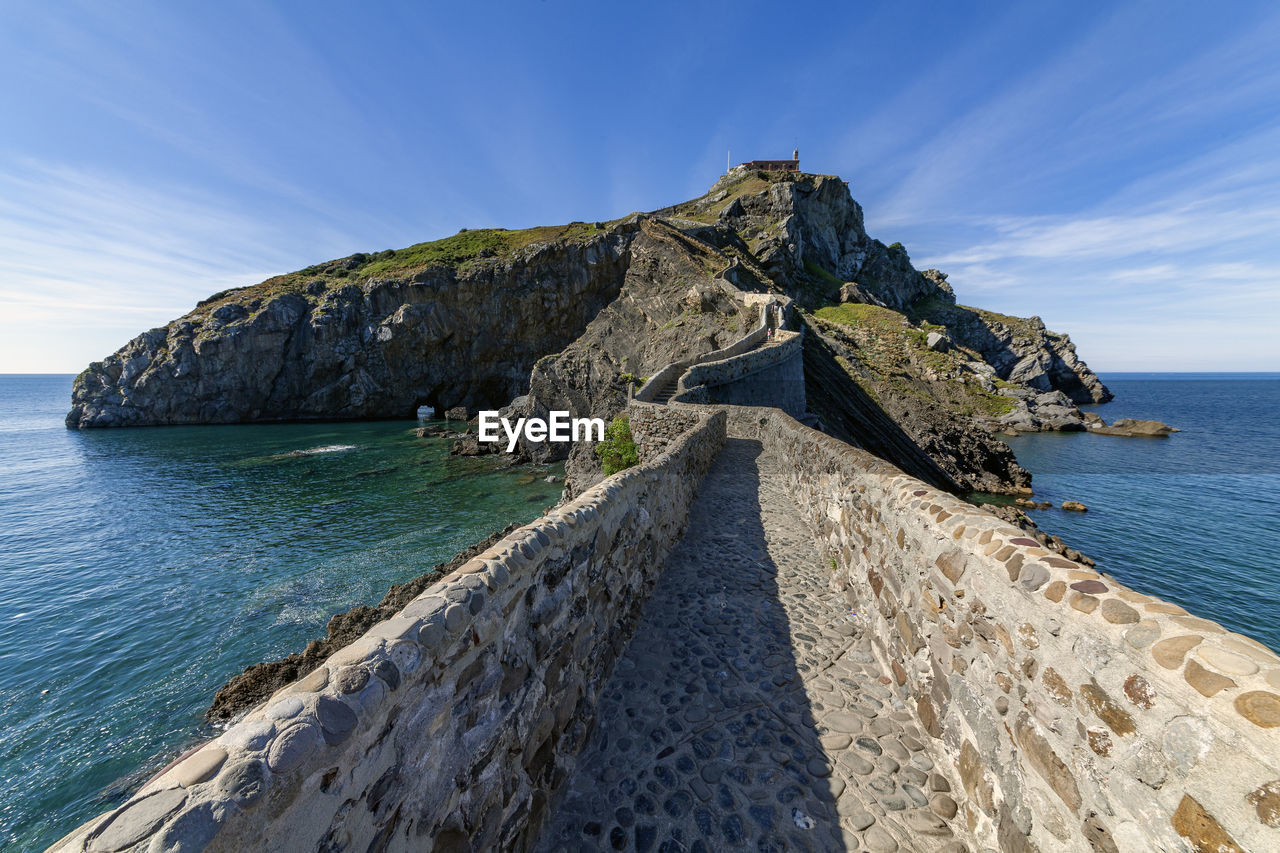 Rock formations by sea against sky