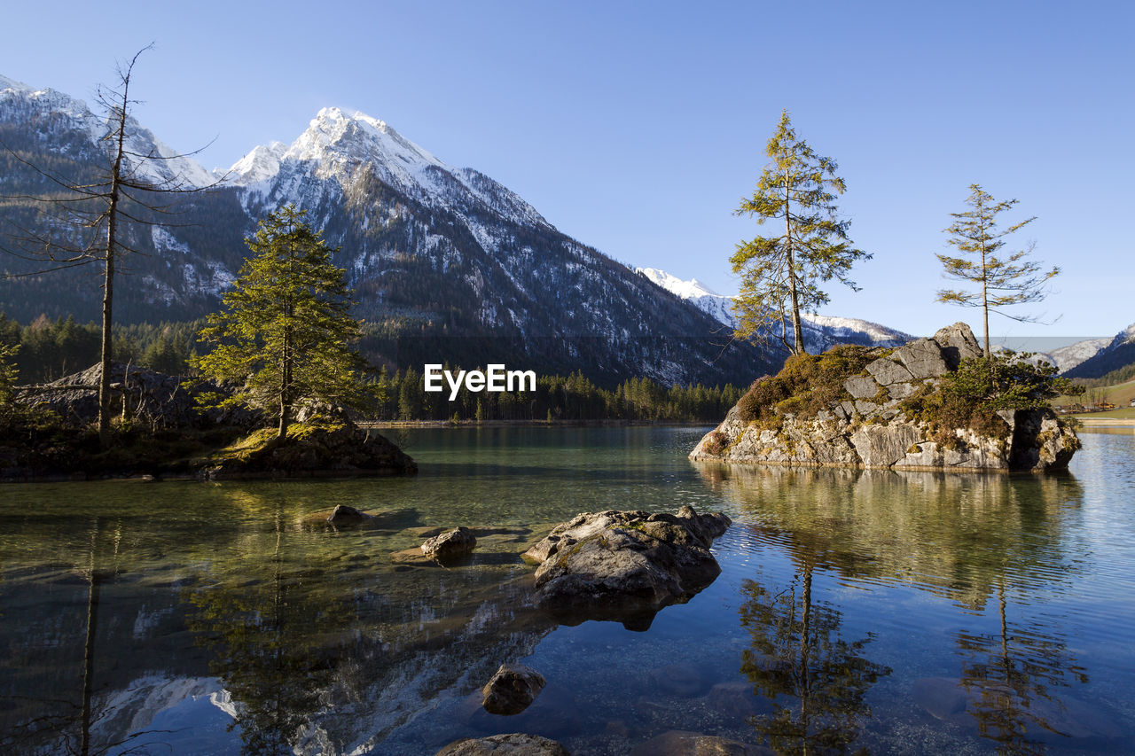 scenic view of lake by mountains against sky