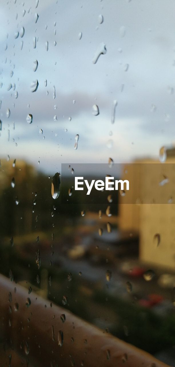 CLOSE-UP OF RAINDROPS ON WINDOW GLASS