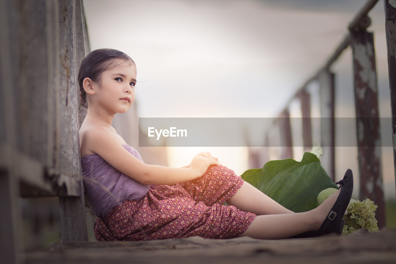 Young woman sitting on railing