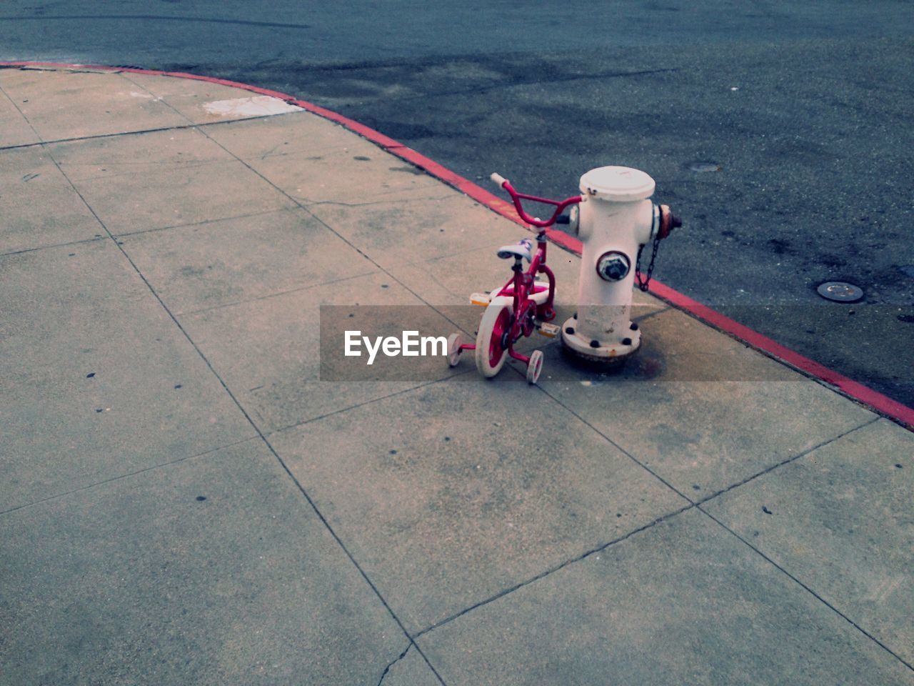 High angle view of bicycle by fire hydrant on sidewalk