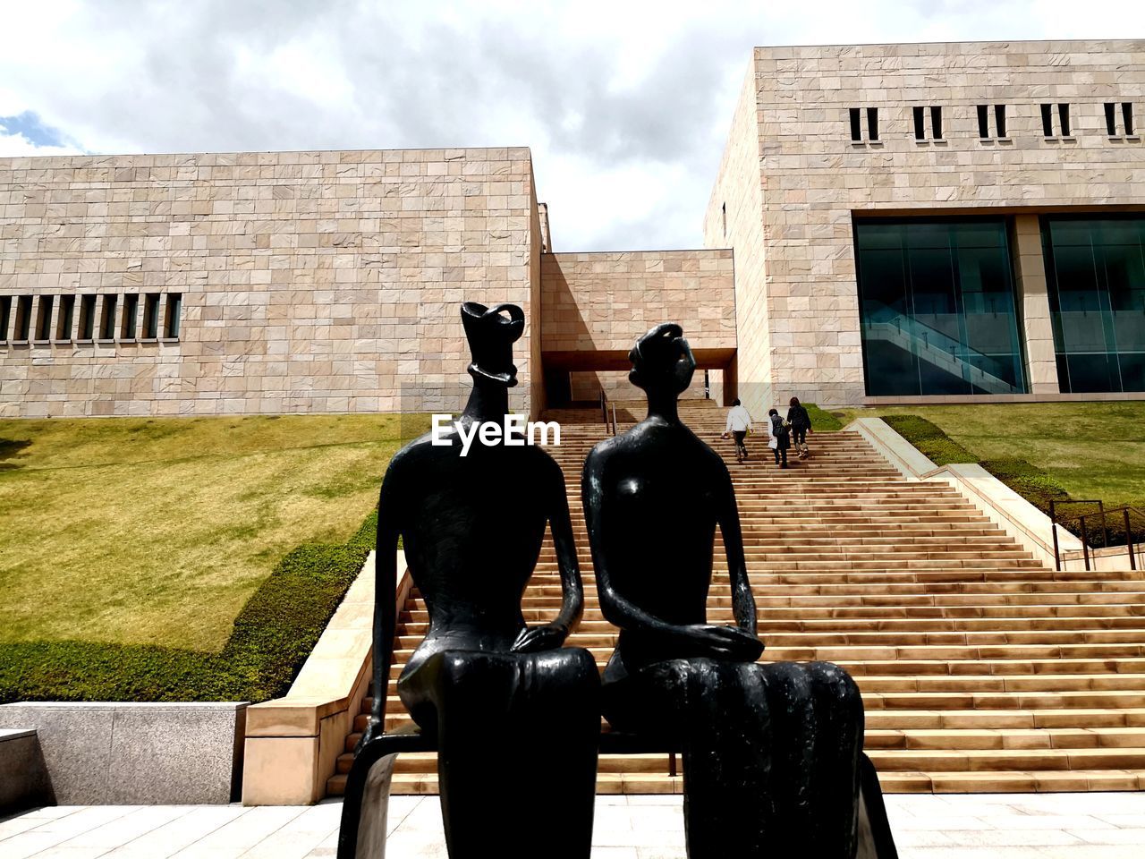 STATUE OF MAN AND WOMAN AGAINST BUILDING