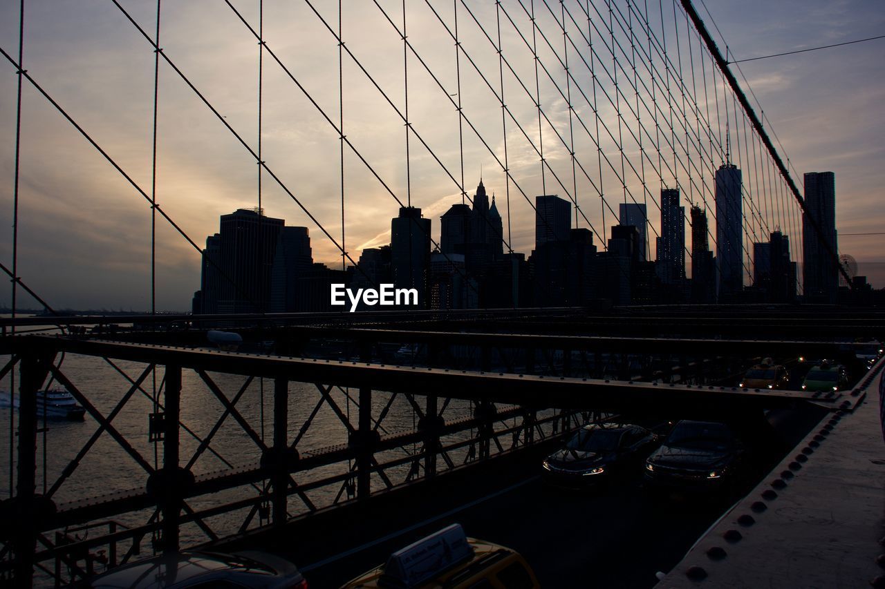 SUSPENSION BRIDGE IN CITY AGAINST SKY