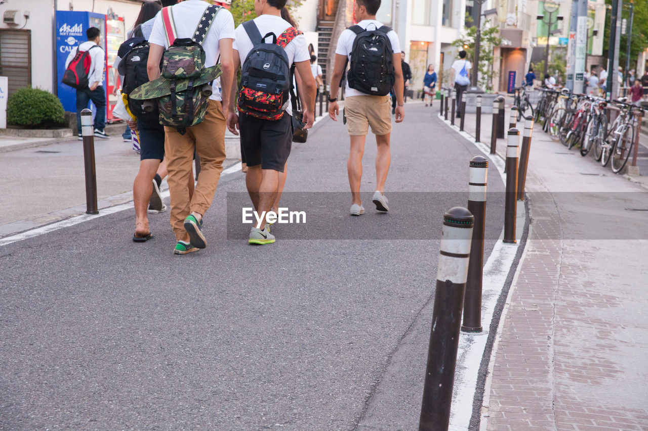 WOMAN WALKING ON ROAD IN CITY