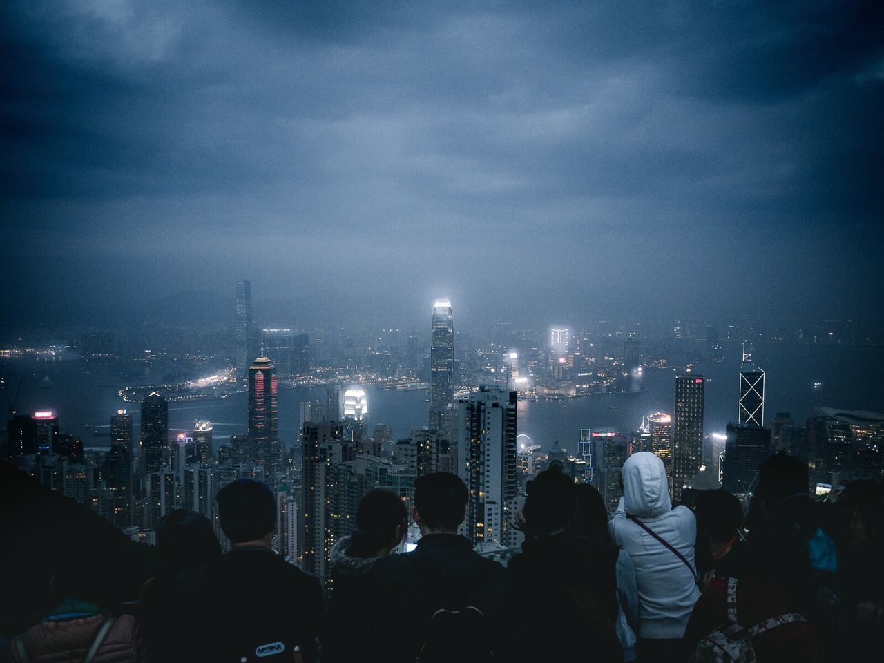 High angle view of people looking at city skyline at night