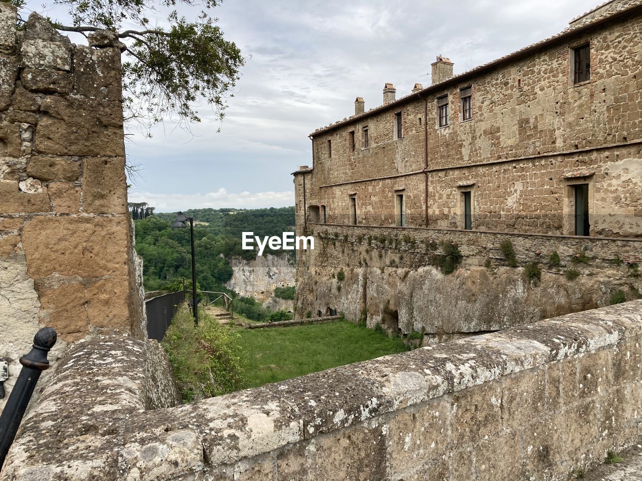 architecture, wall, ruins, fortification, history, built structure, ancient history, the past, building exterior, sky, nature, building, wall - building feature, stone wall, ancient, cloud, travel destinations, fort, stone material, old, old ruin, no people, travel, plant, castle, tourism, surrounding wall, village, outdoors, town, medieval, day, fortified wall, tree, rock, city, château