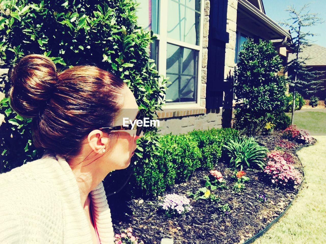 WOMAN STANDING BY PLANTS