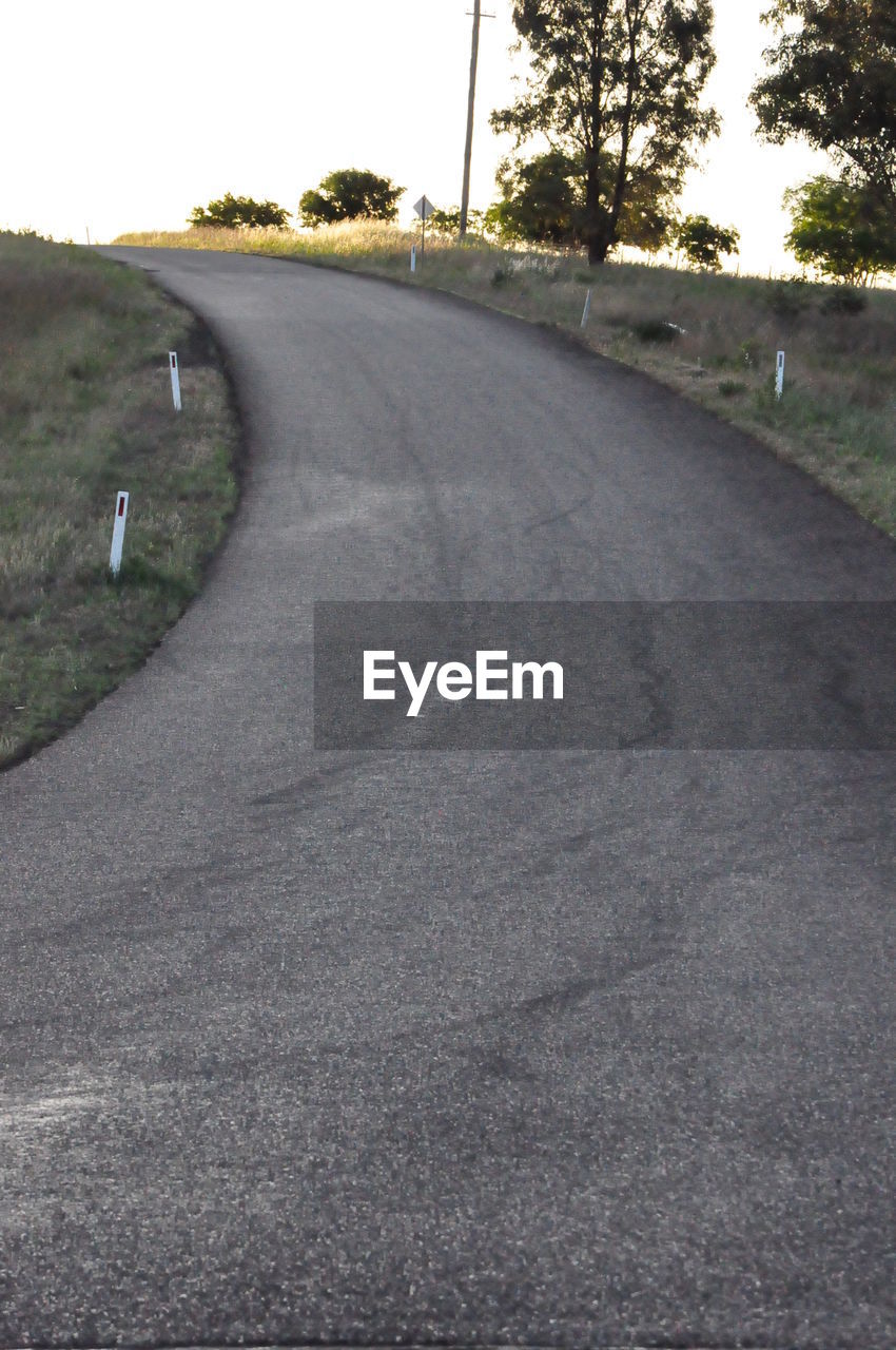 EMPTY ROAD LEADING TOWARDS TREES