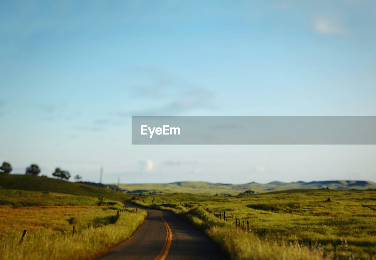 Empty road along countryside landscape