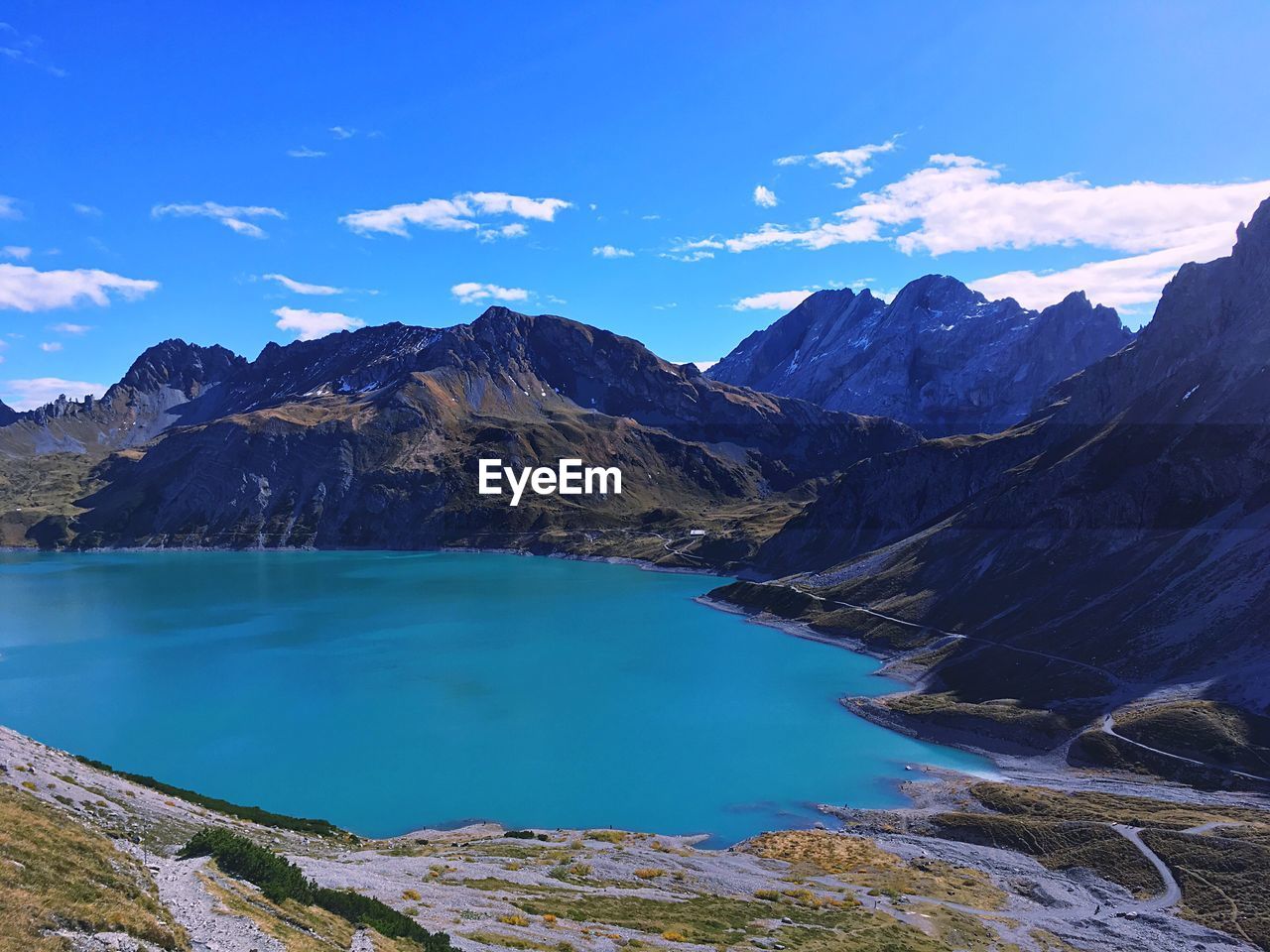 Scenic view of lake and mountains against blue sky