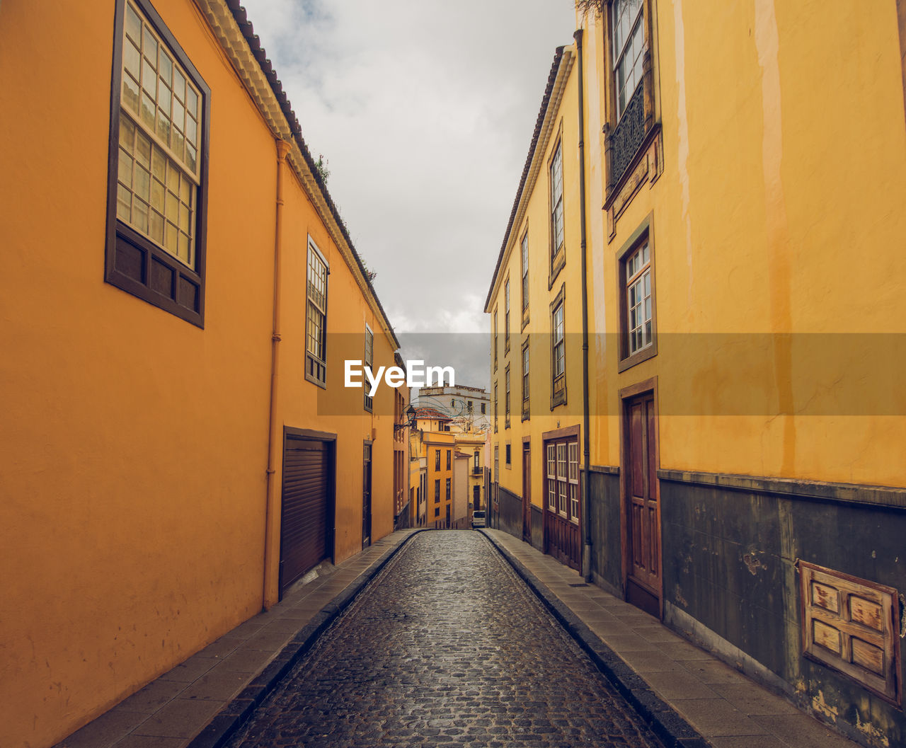 Empty alley amidst buildings in city