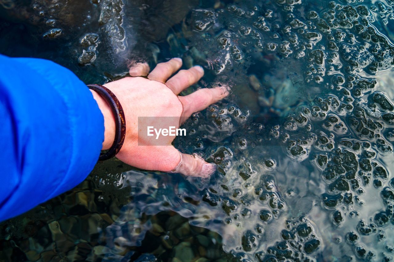 Cropped hand of person in lake
