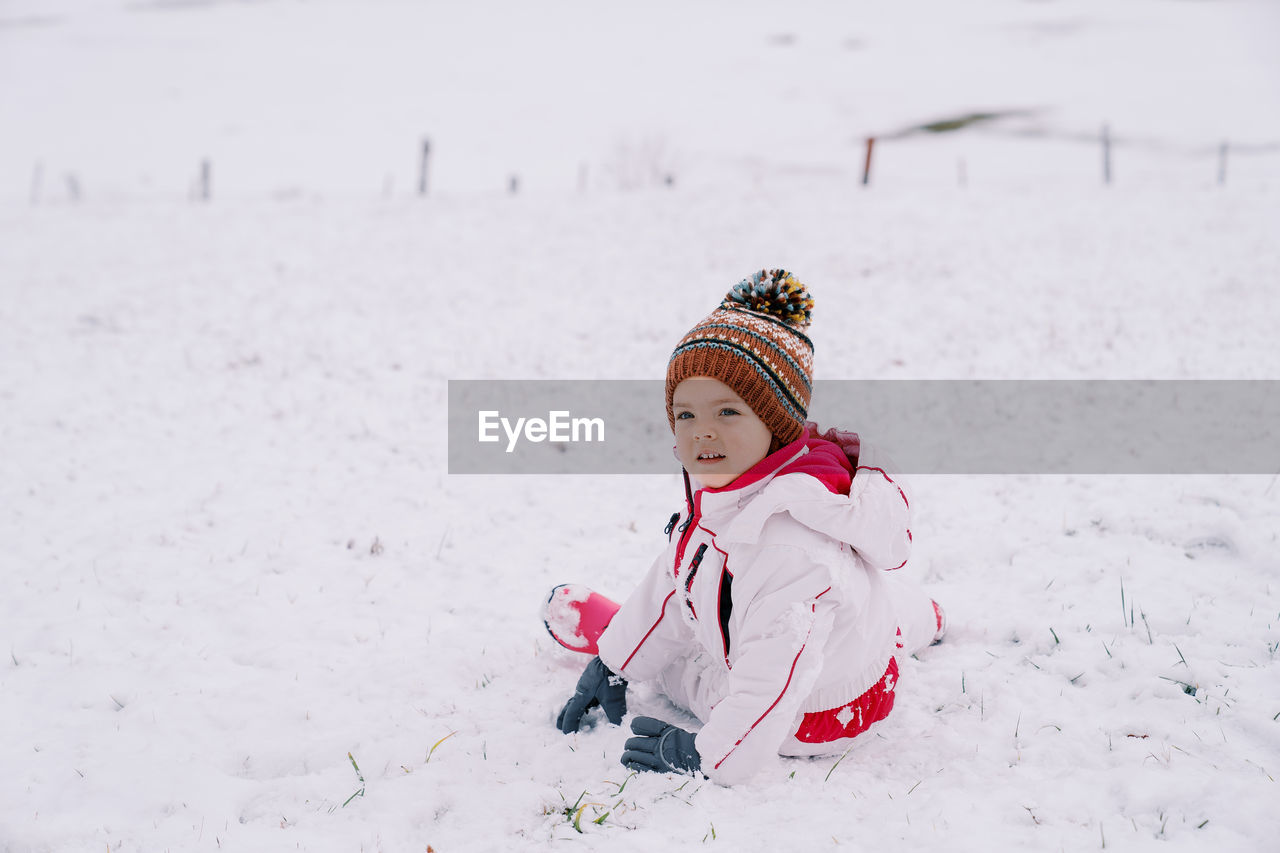 full length of woman skiing on snow covered landscape