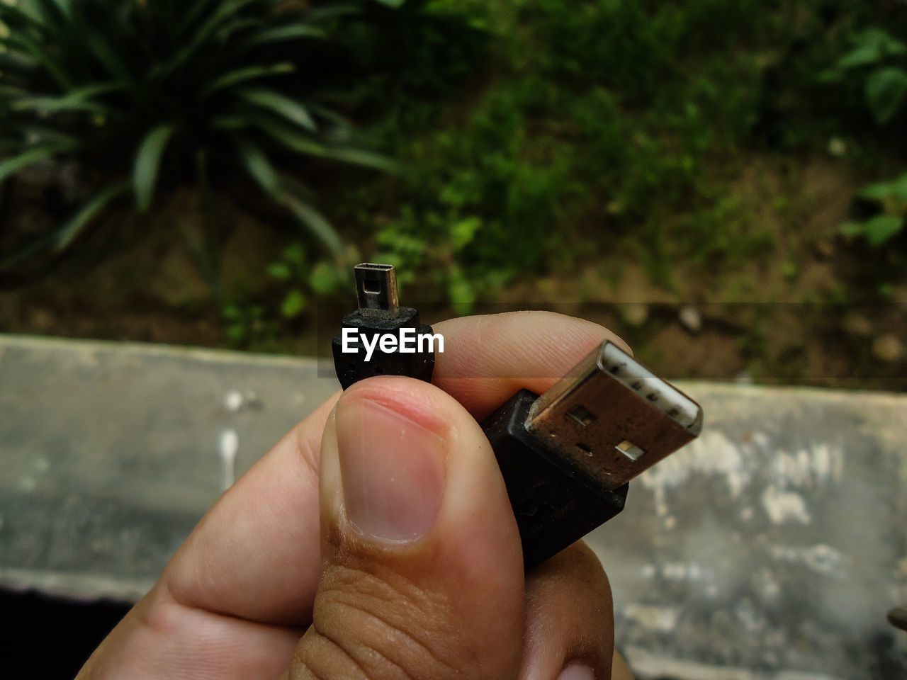 CLOSE-UP OF HAND HOLDING CAMERA