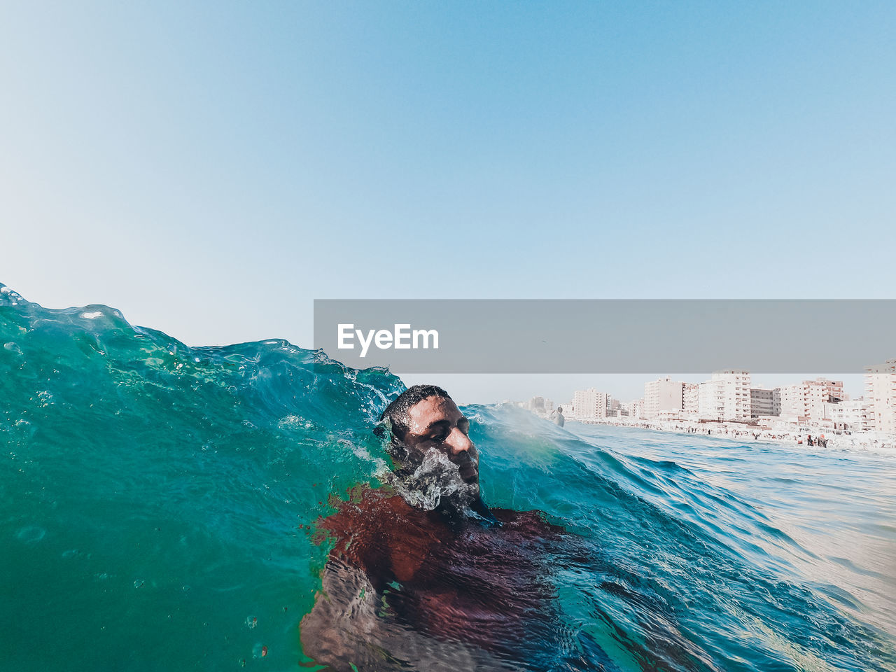 Man swimming in blue sea against sky