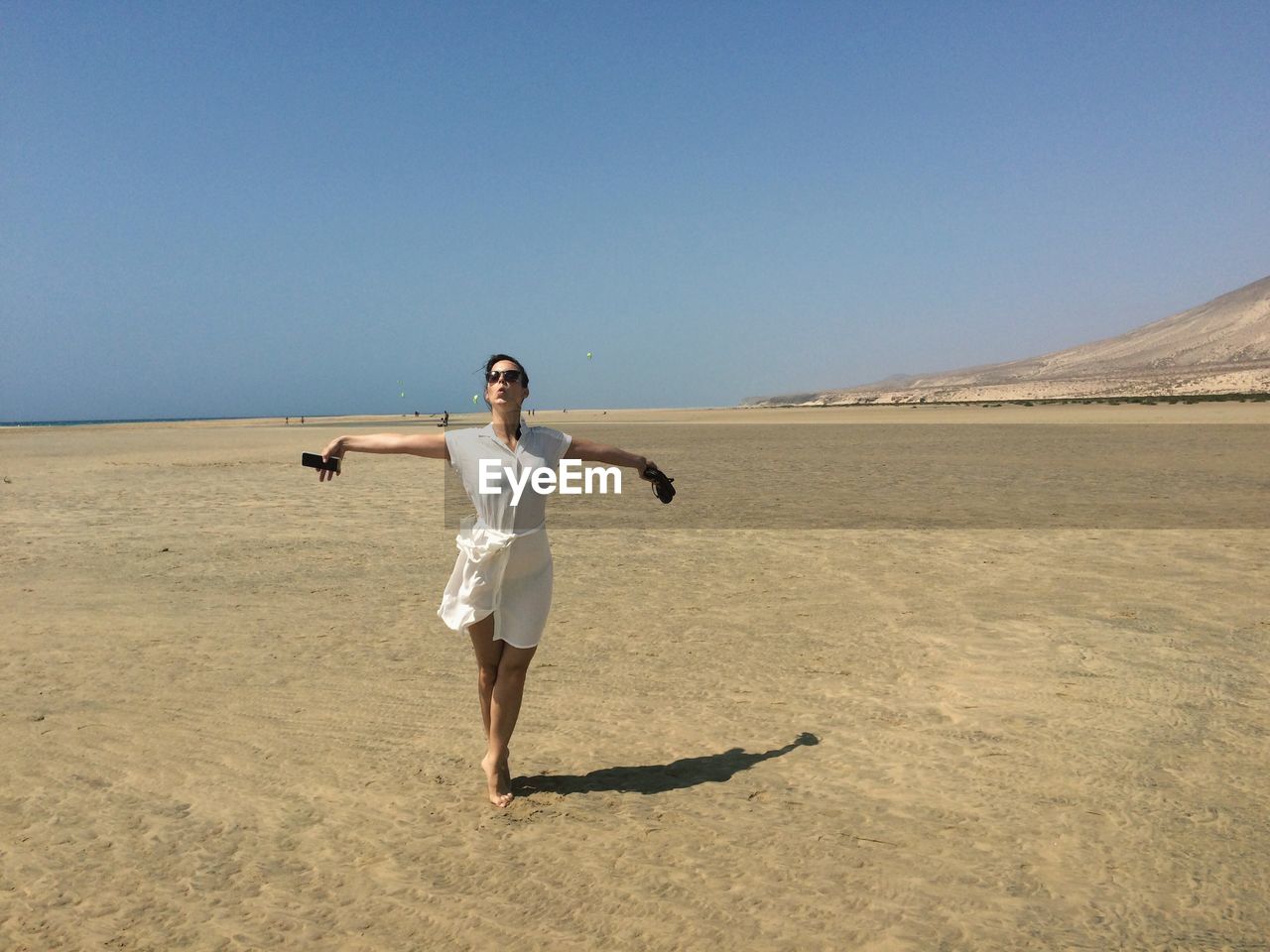 WOMAN STANDING ON BEACH