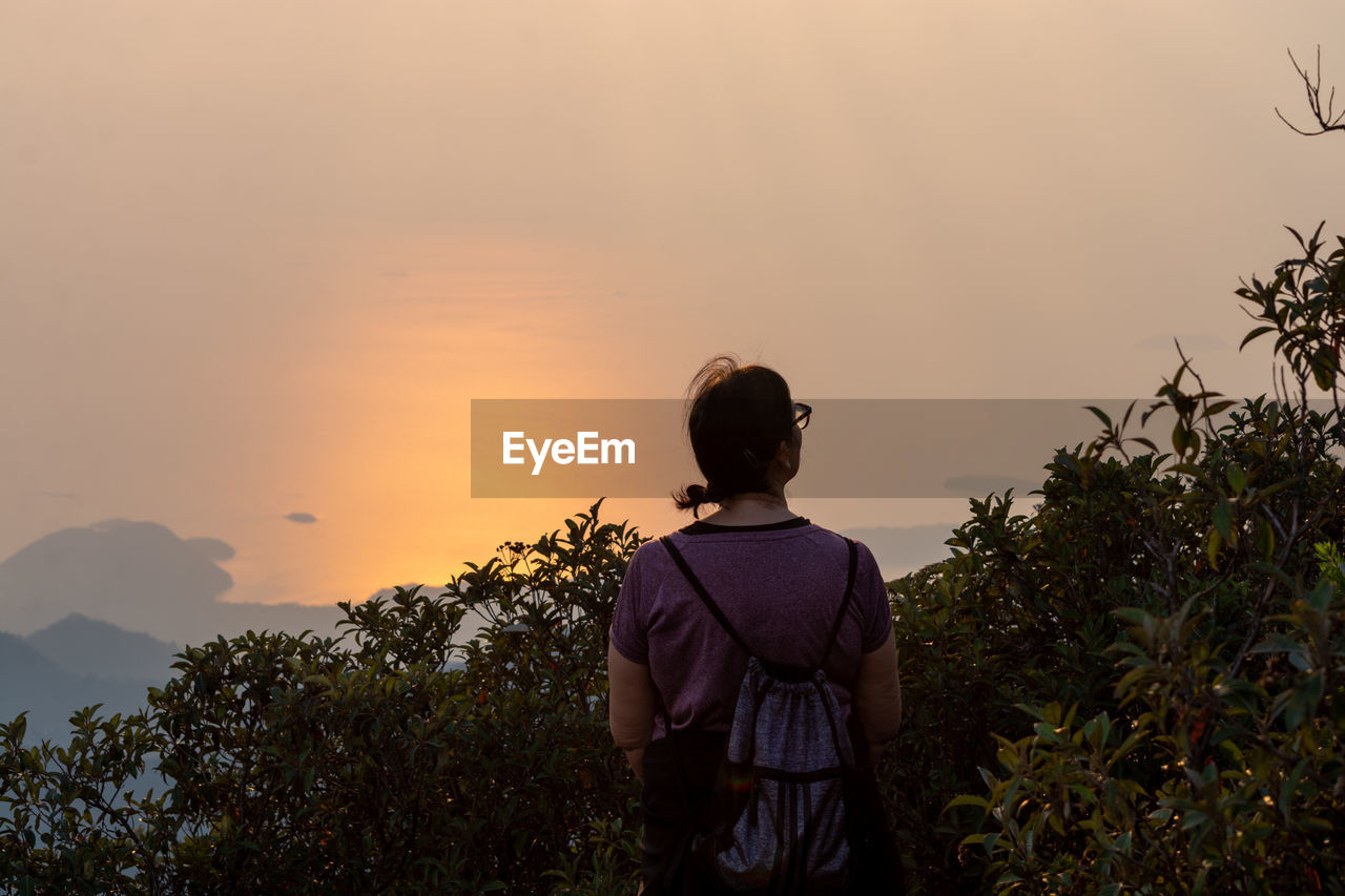 Rear view of man looking at sunset