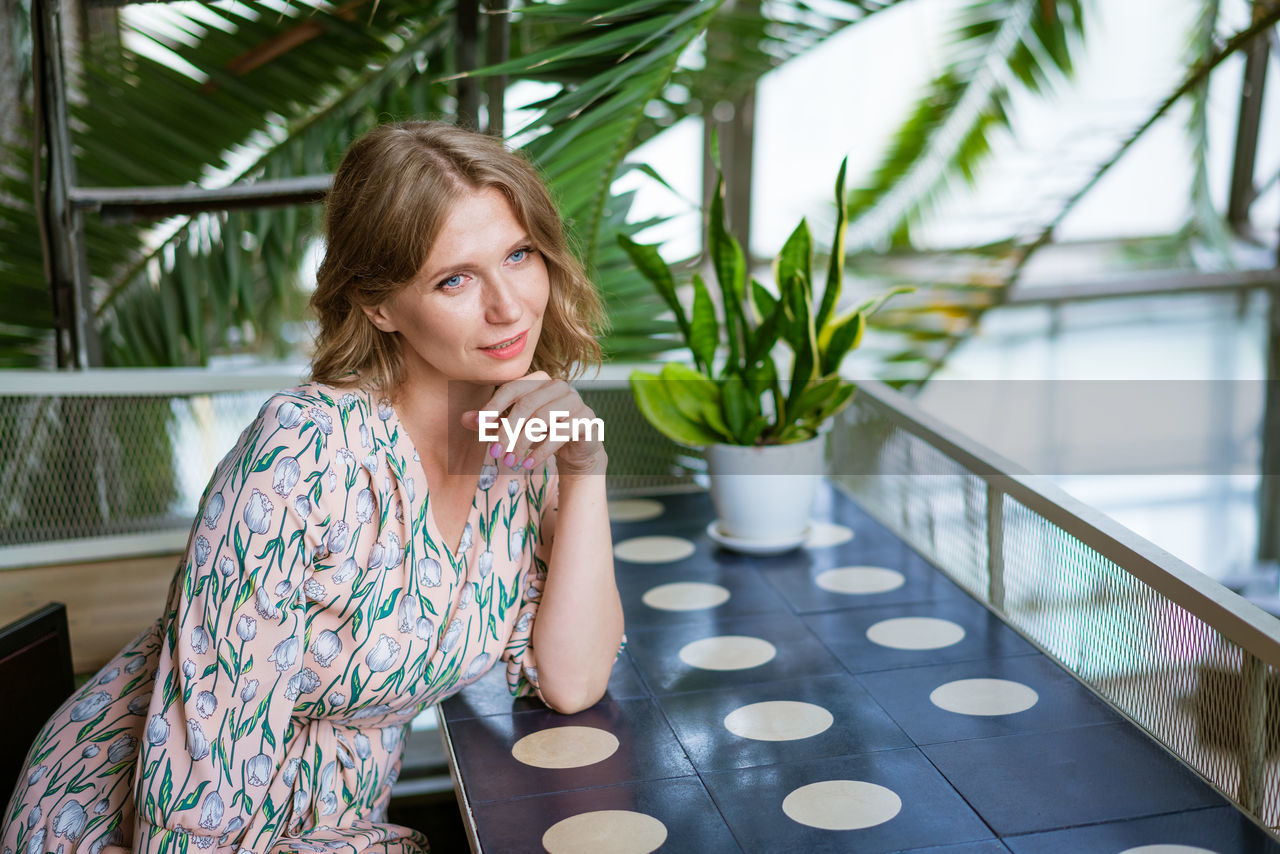 Portrait charming woman is calling, sitting alone in cafe in her free time