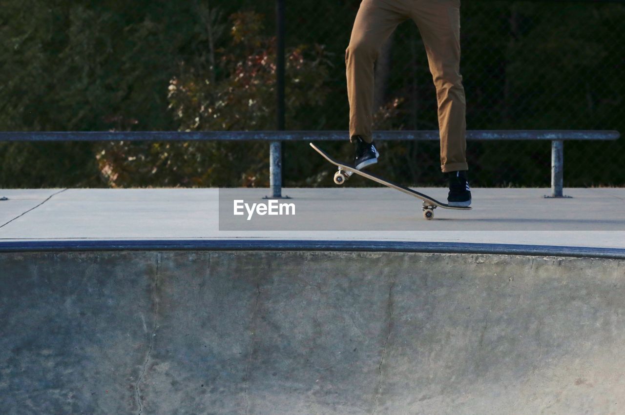 Low section of man skateboarding in park