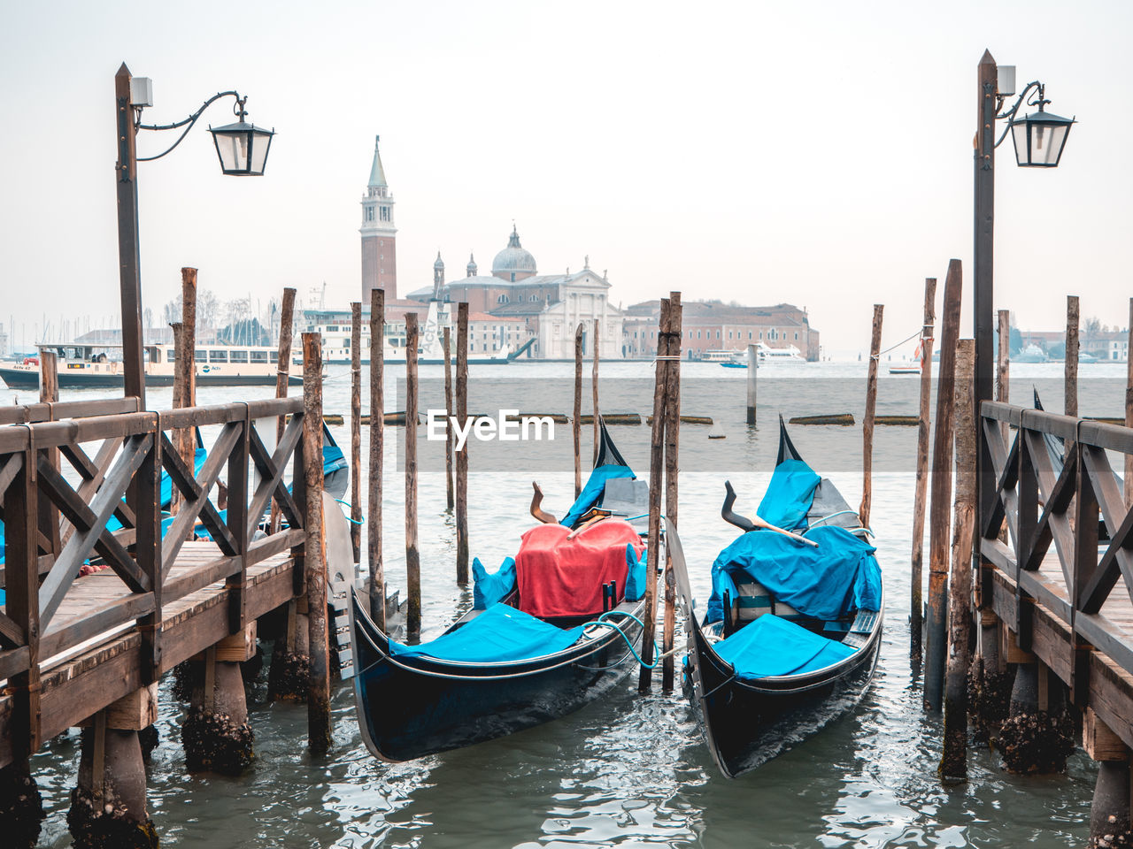 Boats moored on sea against church