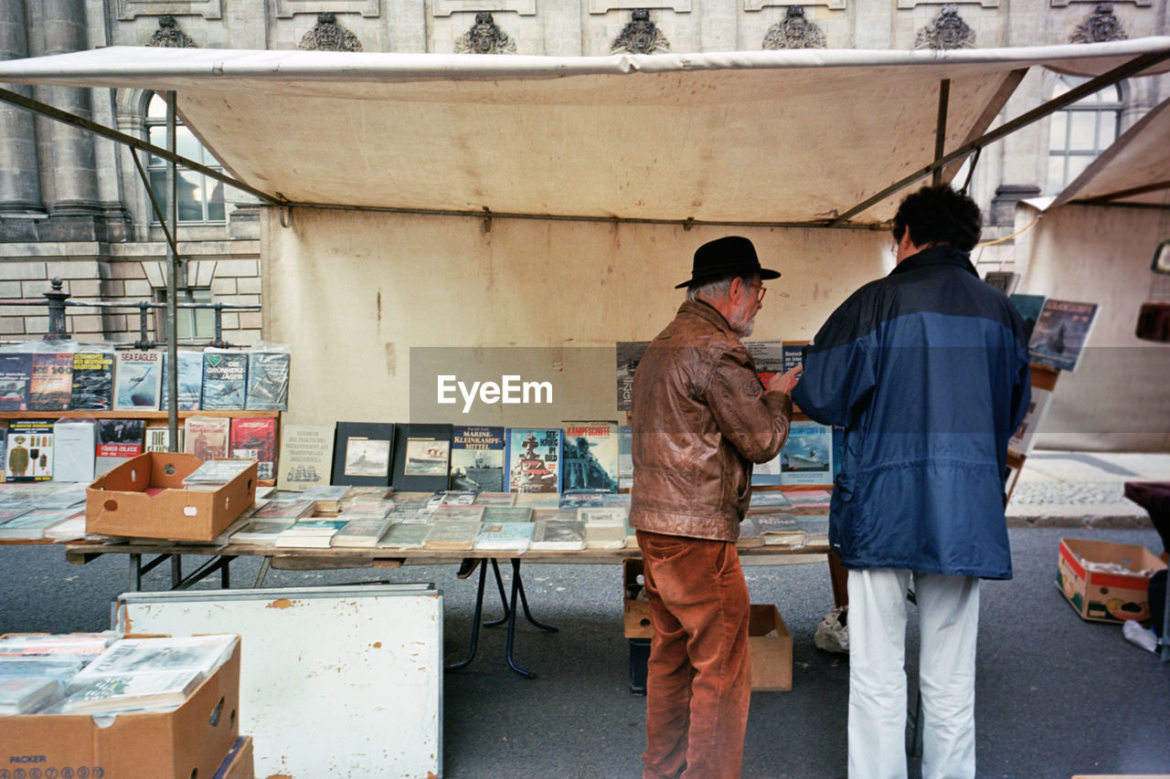 Rear view of men standing by market stall