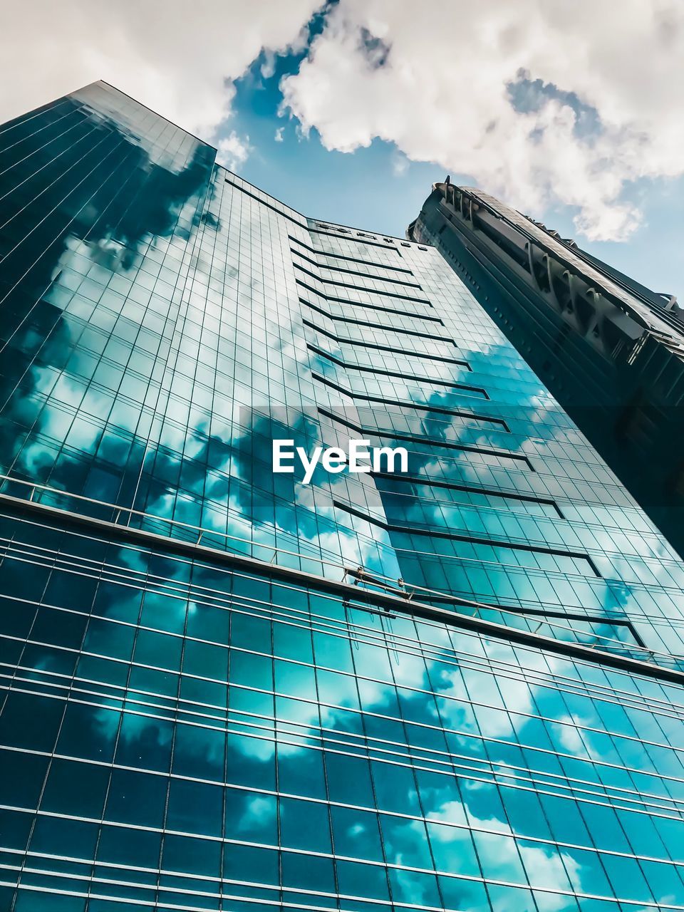 LOW ANGLE VIEW OF GLASS BUILDING AGAINST SKY