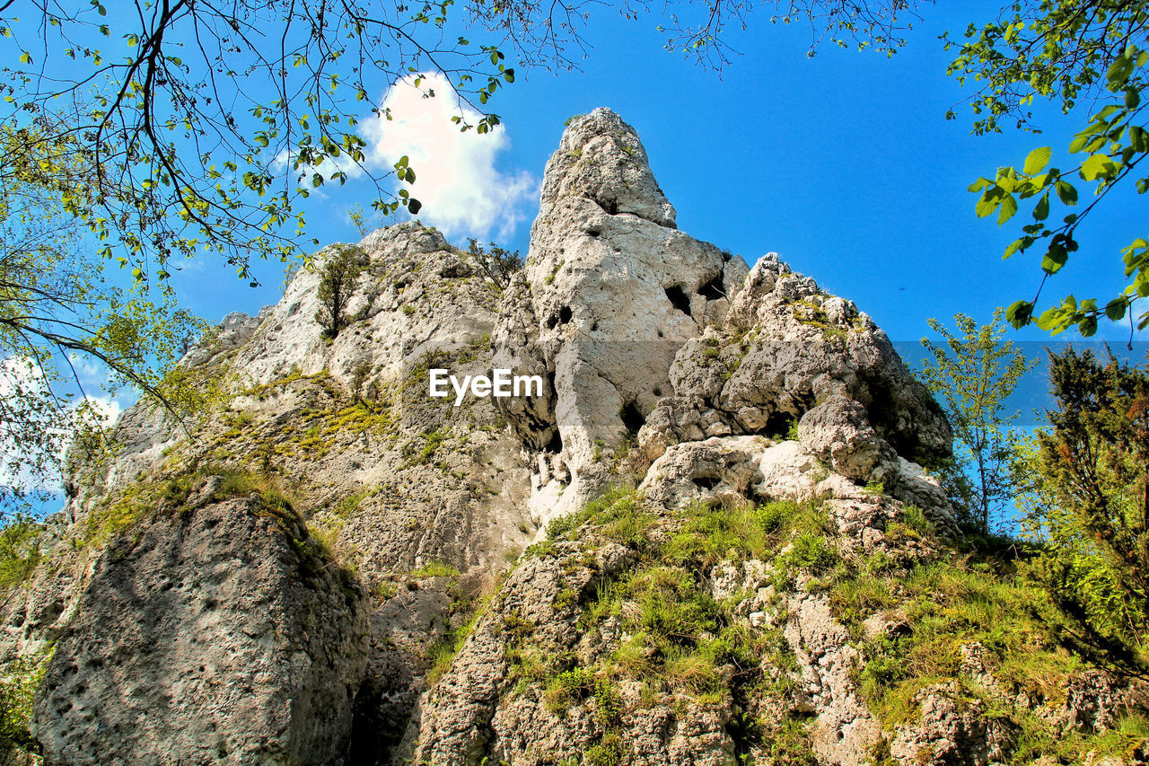 Low angle view of tree mountain against clear blue sky