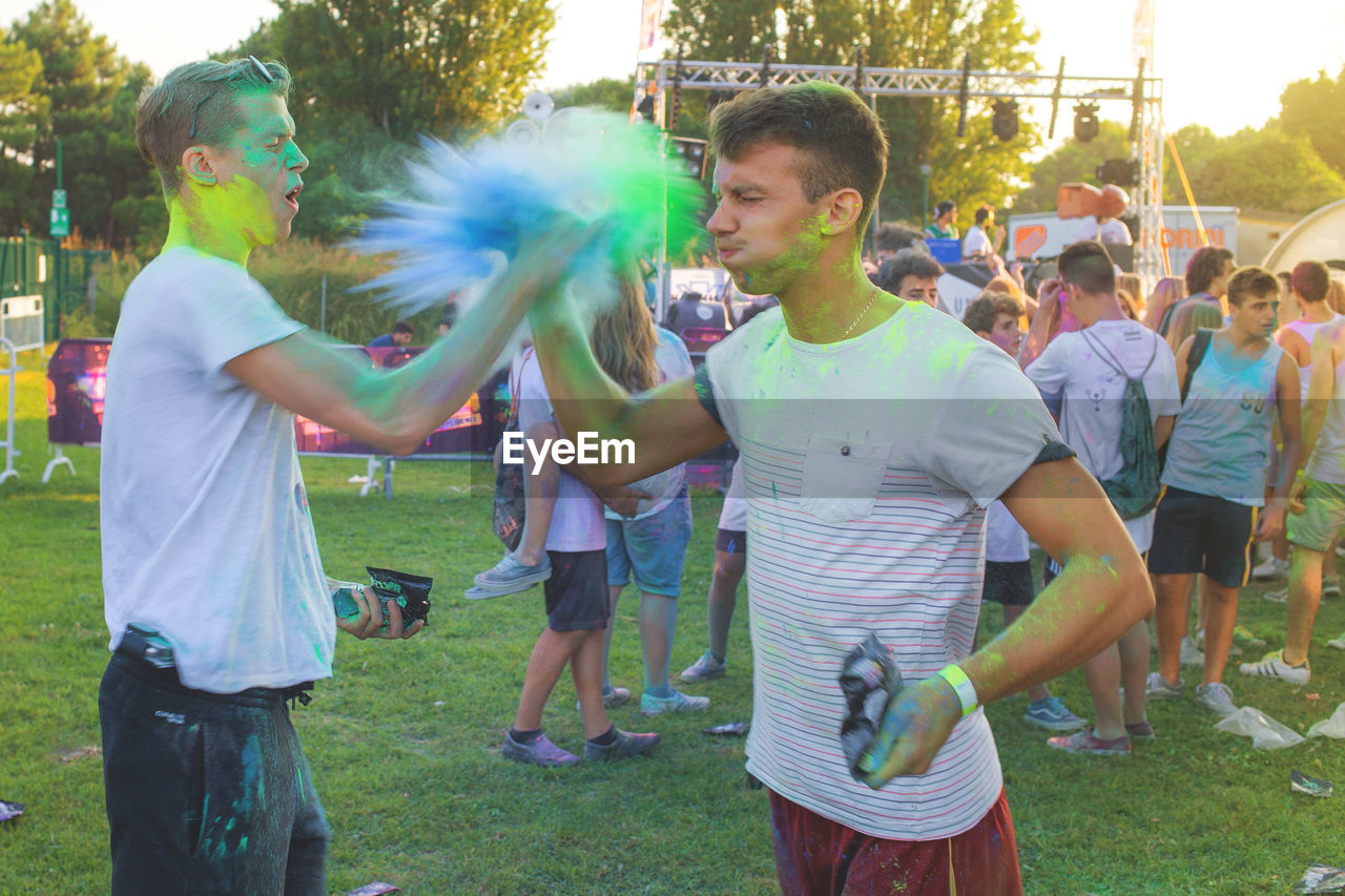 Men playing with powdered paints at event