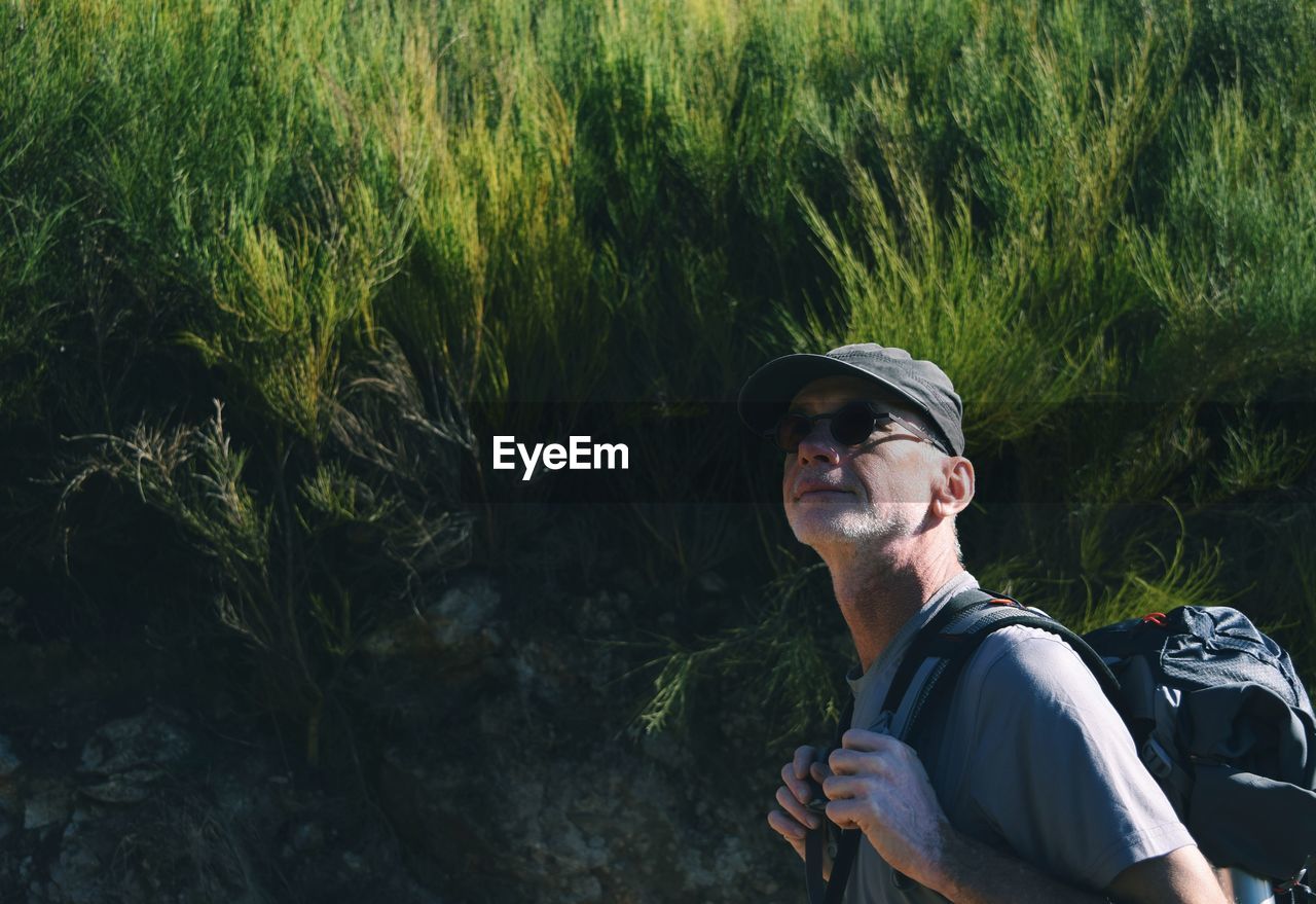 Hiker looking away against plants