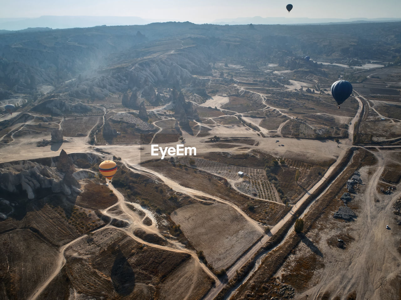 Aerial view of hot air balloon over landscape against sky