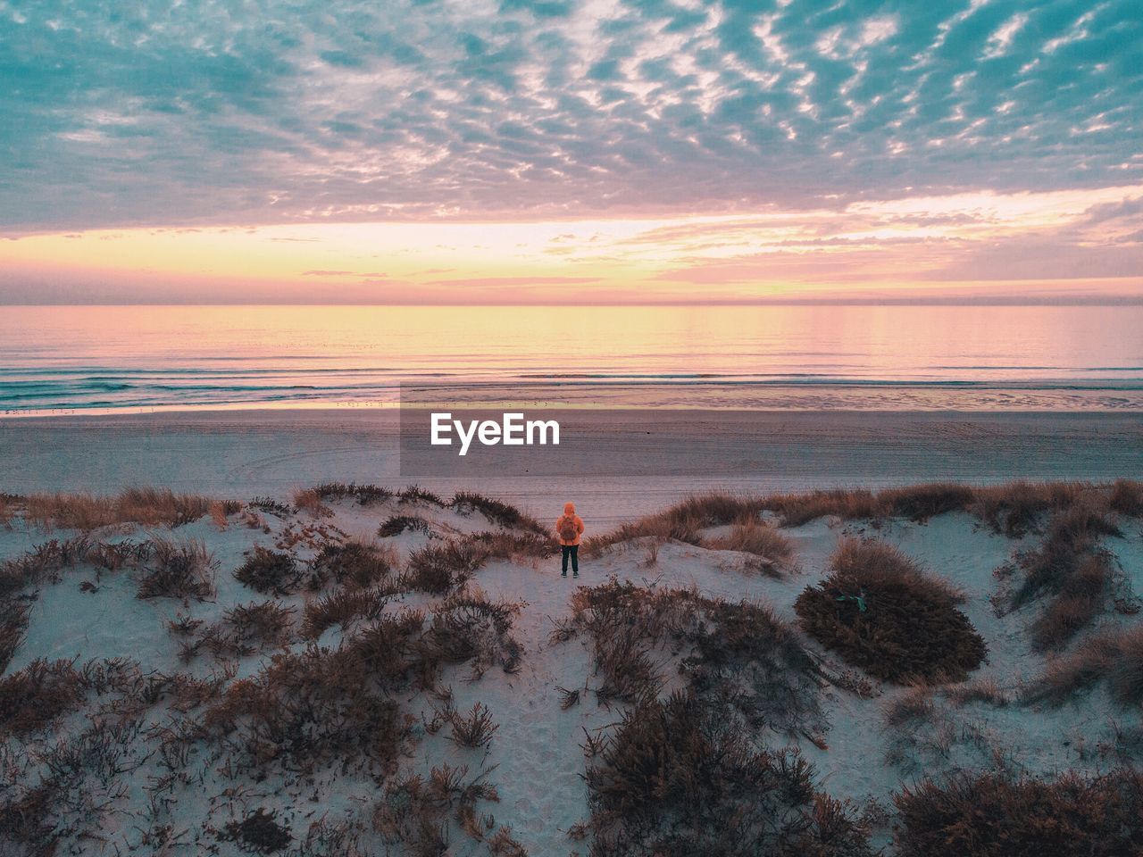 Scenic view of sea against dramatic sky during sunset