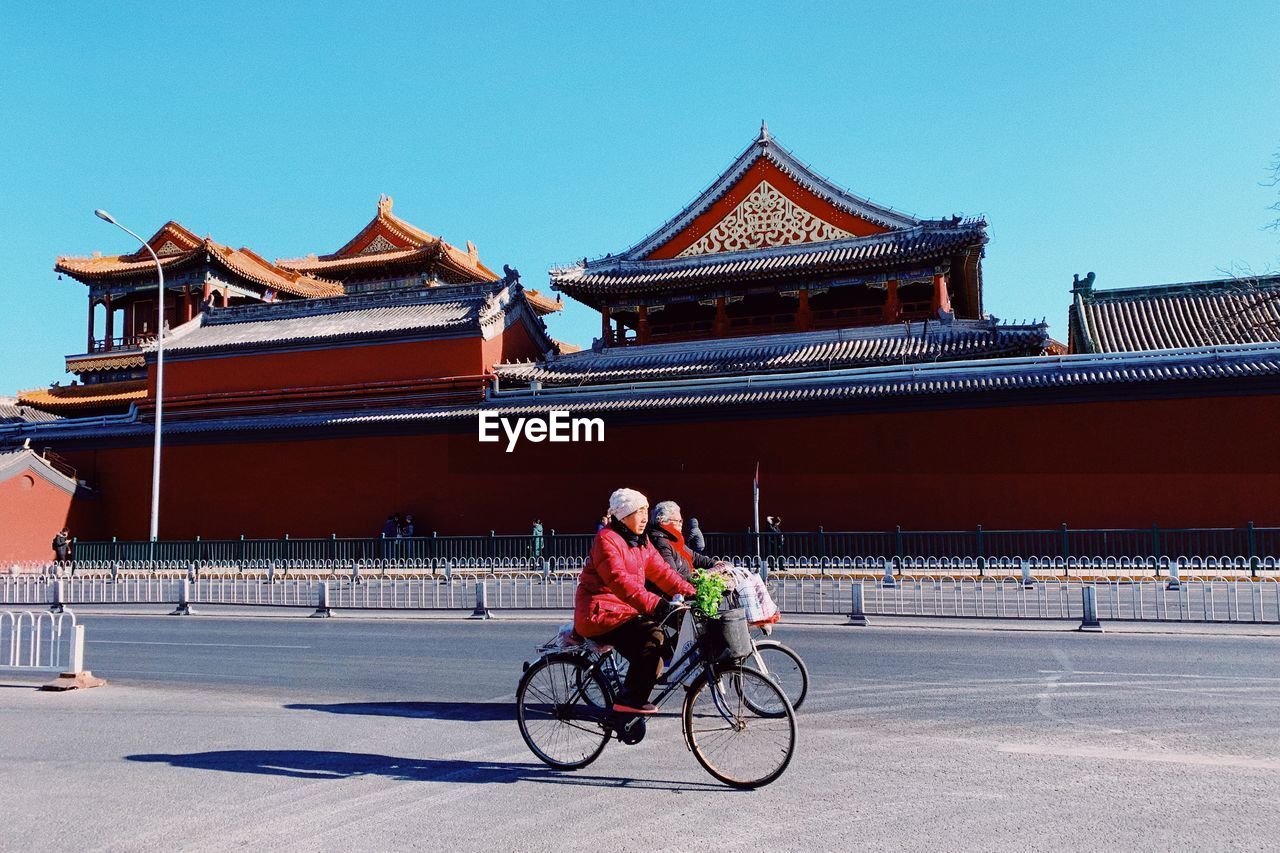 MAN RIDING BICYCLE ON ROAD IN CITY