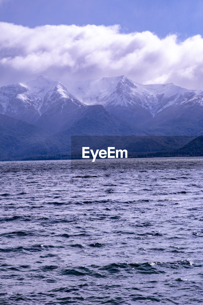 Scenic view of lake and snowcapped mountains against sky