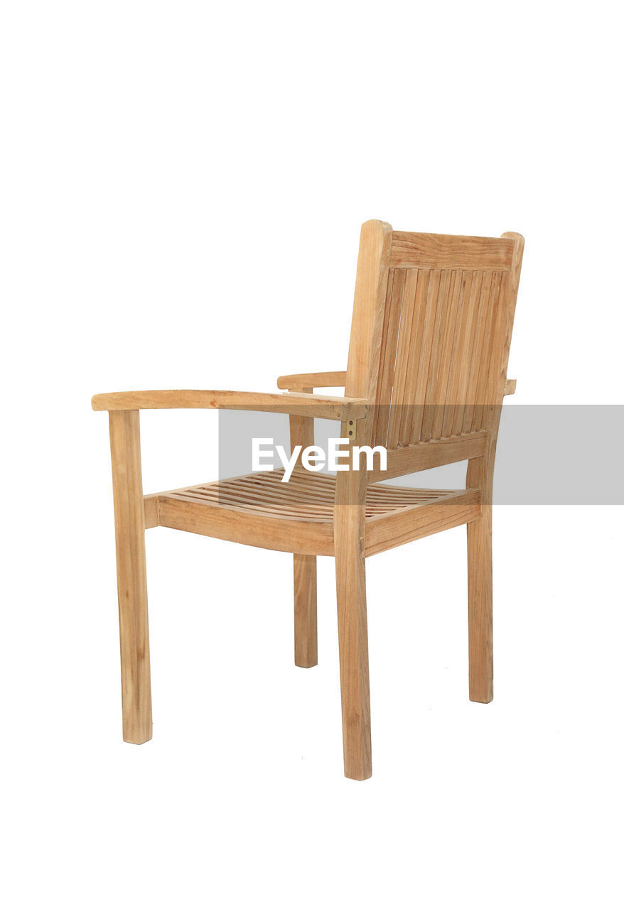 EMPTY CHAIR AND TABLE AGAINST WHITE BACKGROUND
