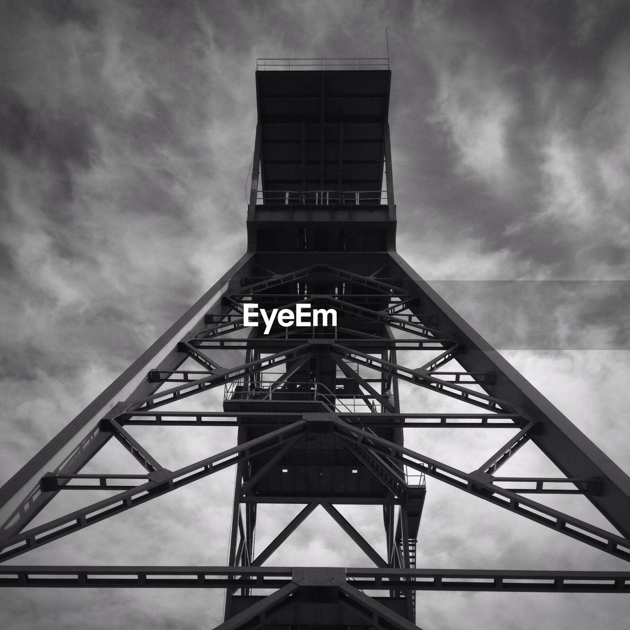 Low angle view of metallic structure against clouds