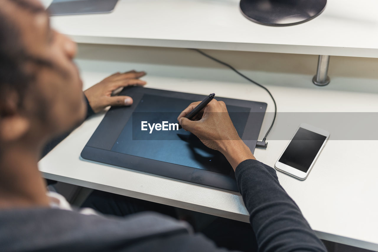 Midsection of man using mobile phone