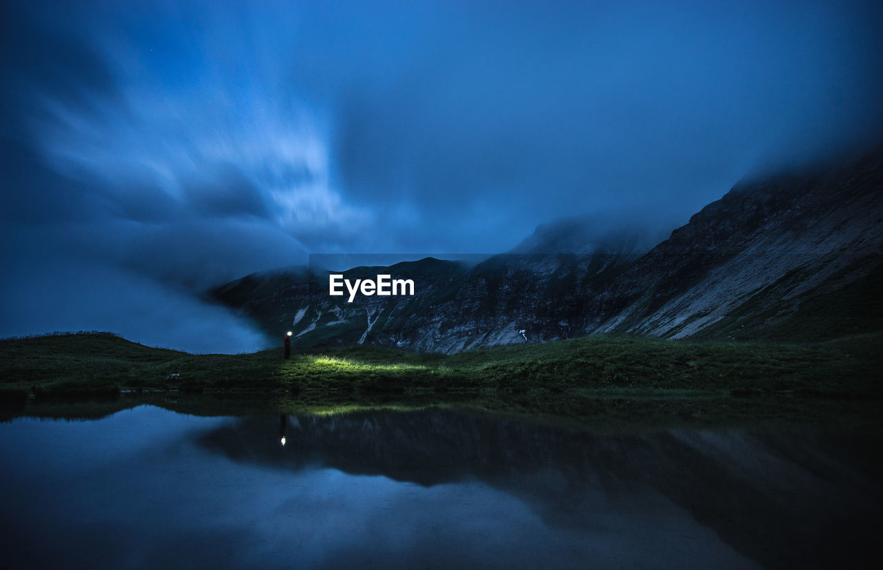 Scenic view of lake against sky at night