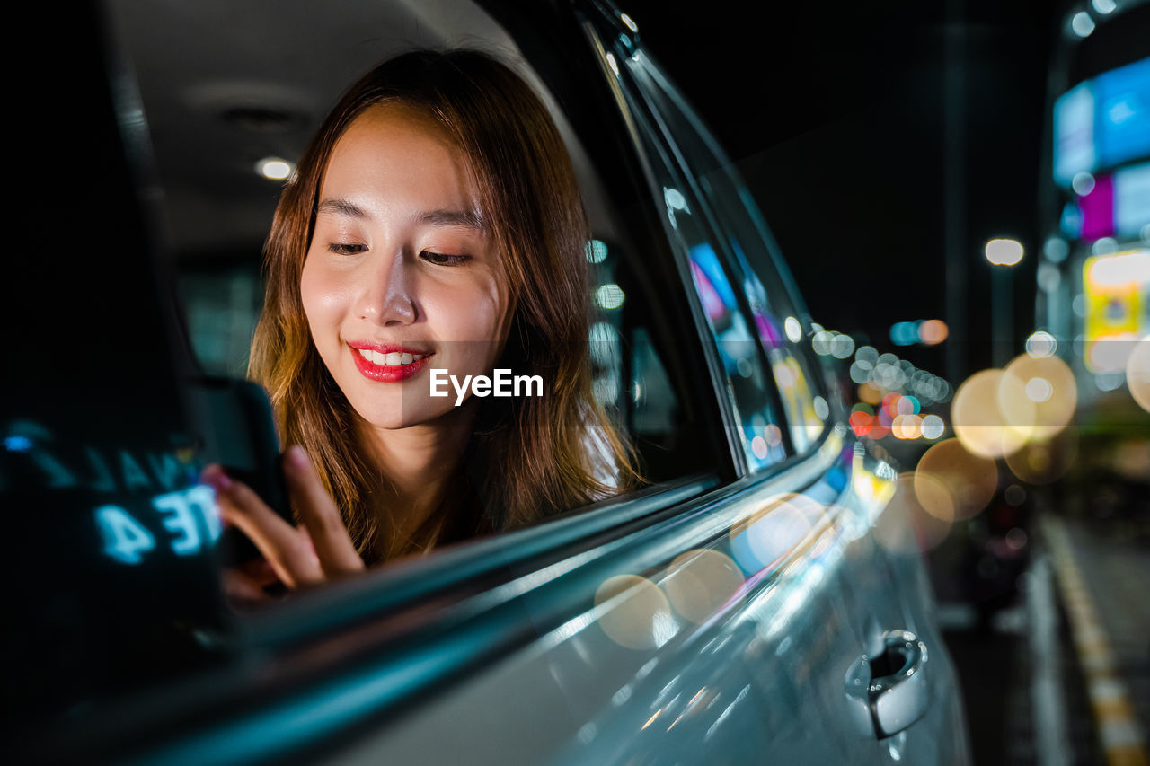 portrait of young woman reflecting on car