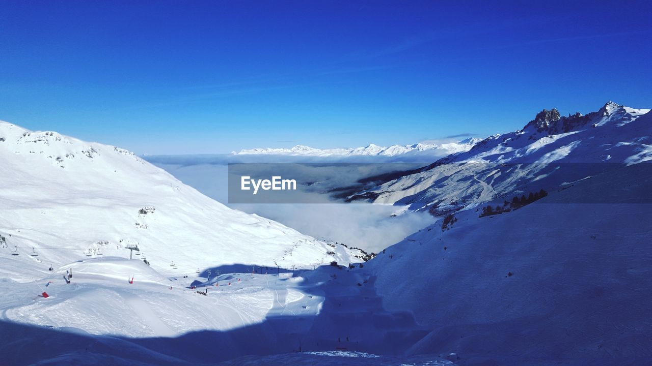 Scenic view of snowcapped mountains against clear blue sky