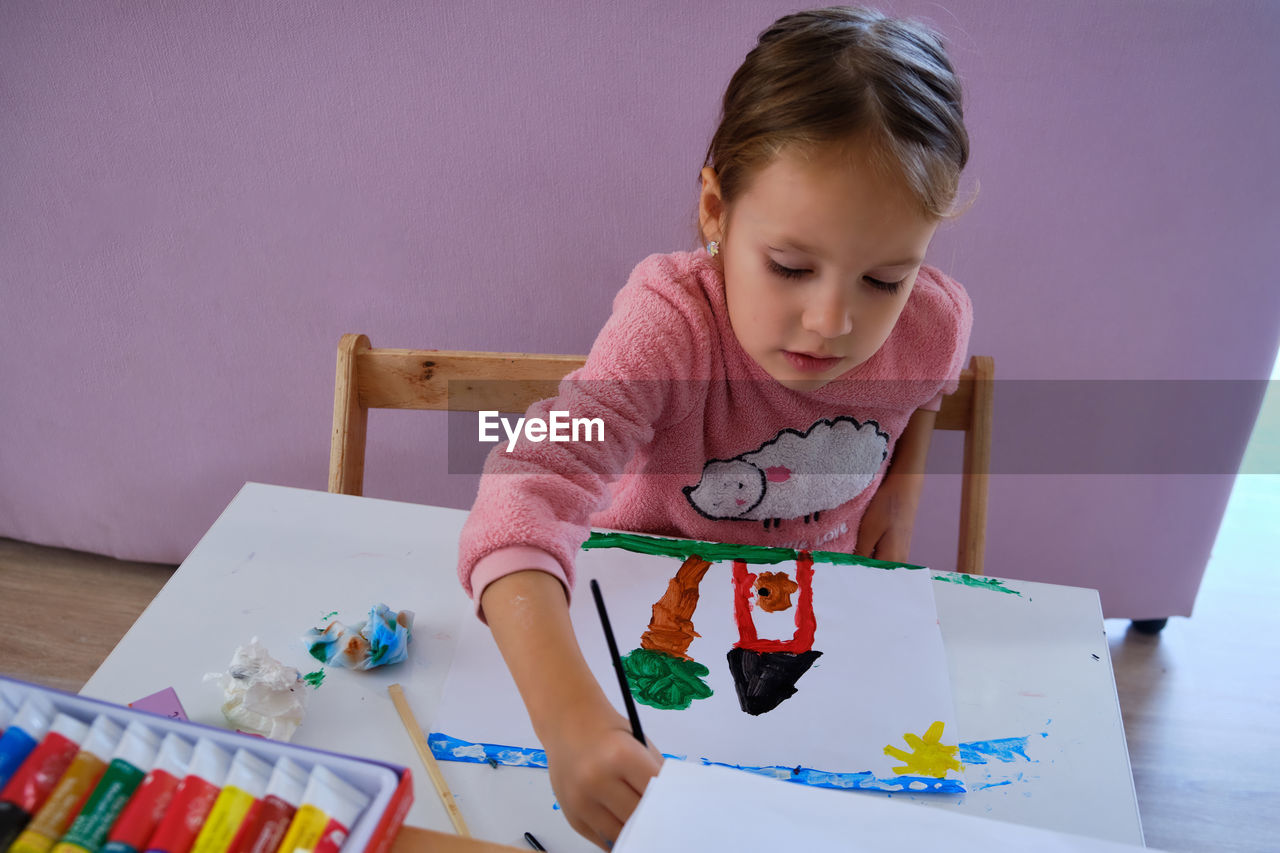 High angle view of woman painting on paper