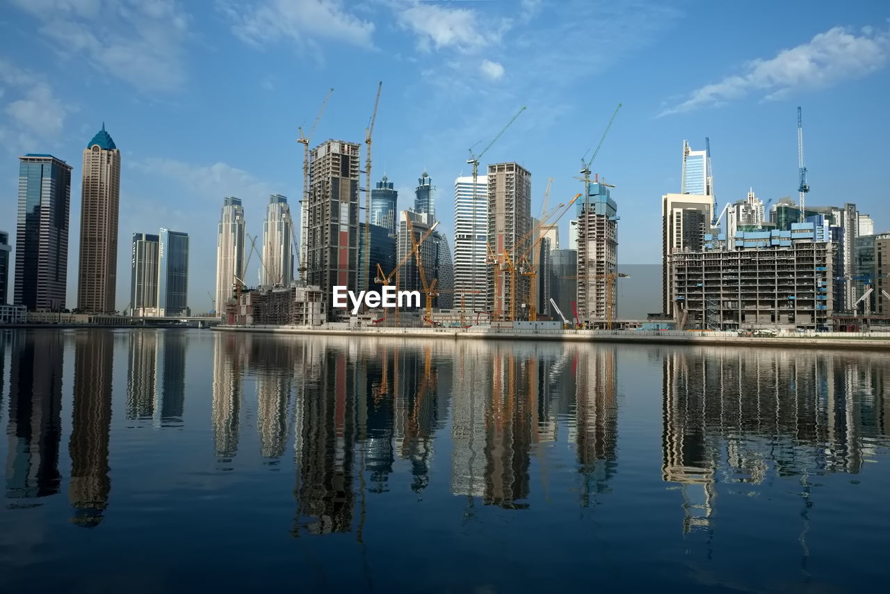 reflection, skyline, city, cityscape, architecture, sky, built structure, water, building exterior, office building exterior, skyscraper, building, landscape, urban skyline, urban area, landmark, horizon, metropolis, nature, cloud, downtown, dusk, waterfront, tower block, office, residential district, no people, metropolitan area, downtown district, travel destinations, evening, business, dock, blue, outdoors, lake, development, business finance and industry, tower, day, travel, finance