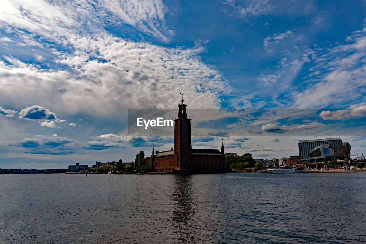 View of building by lake against sky