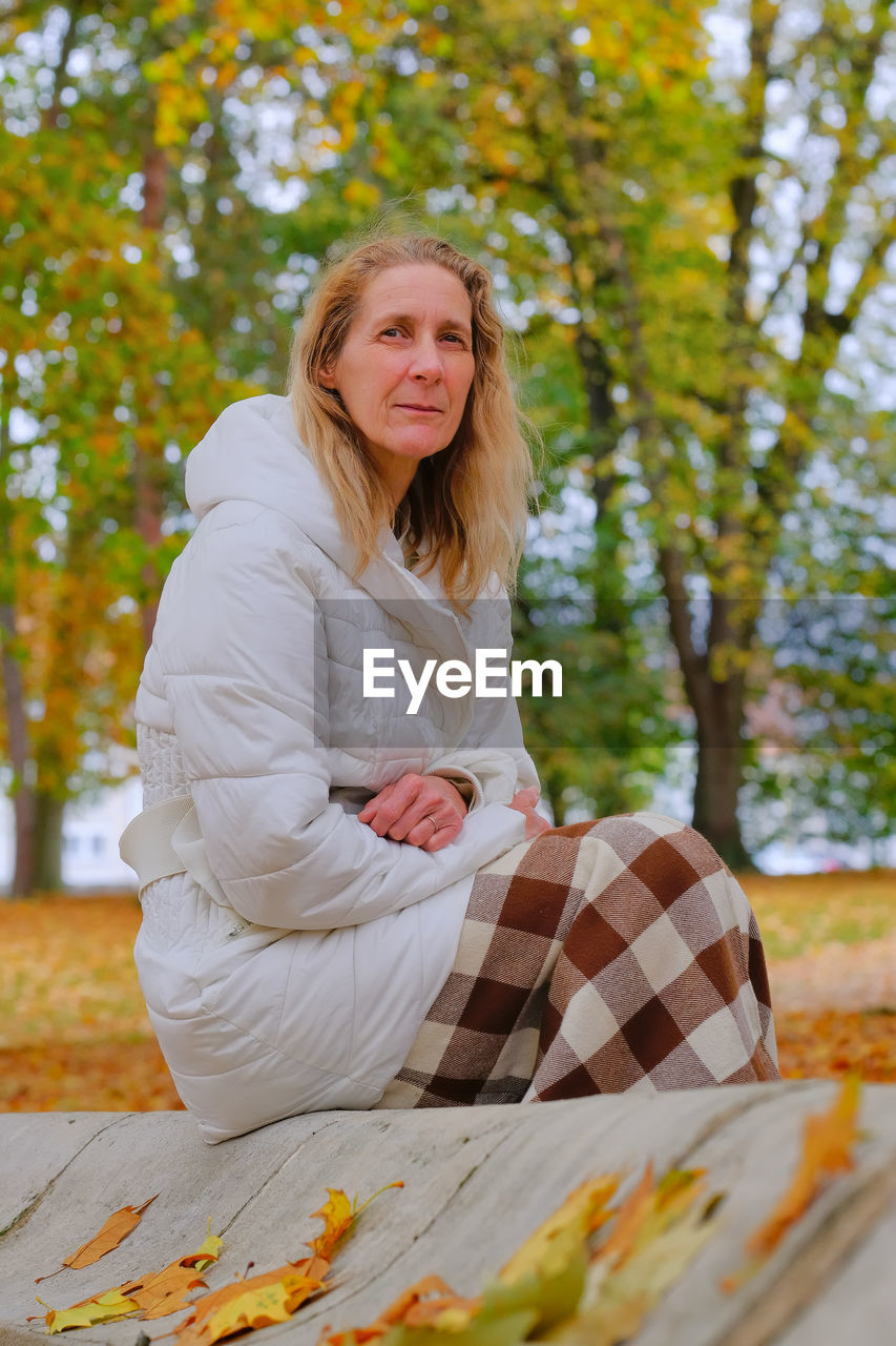 Portrait of woman sitting on tree