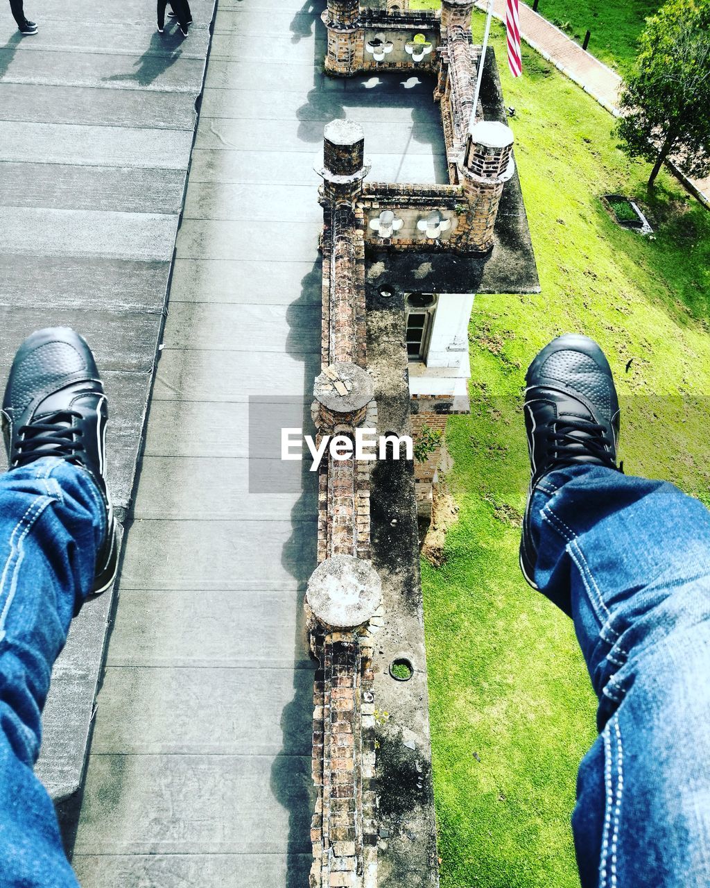 LOW SECTION OF MAN WEARING SHOES STANDING ON WATER