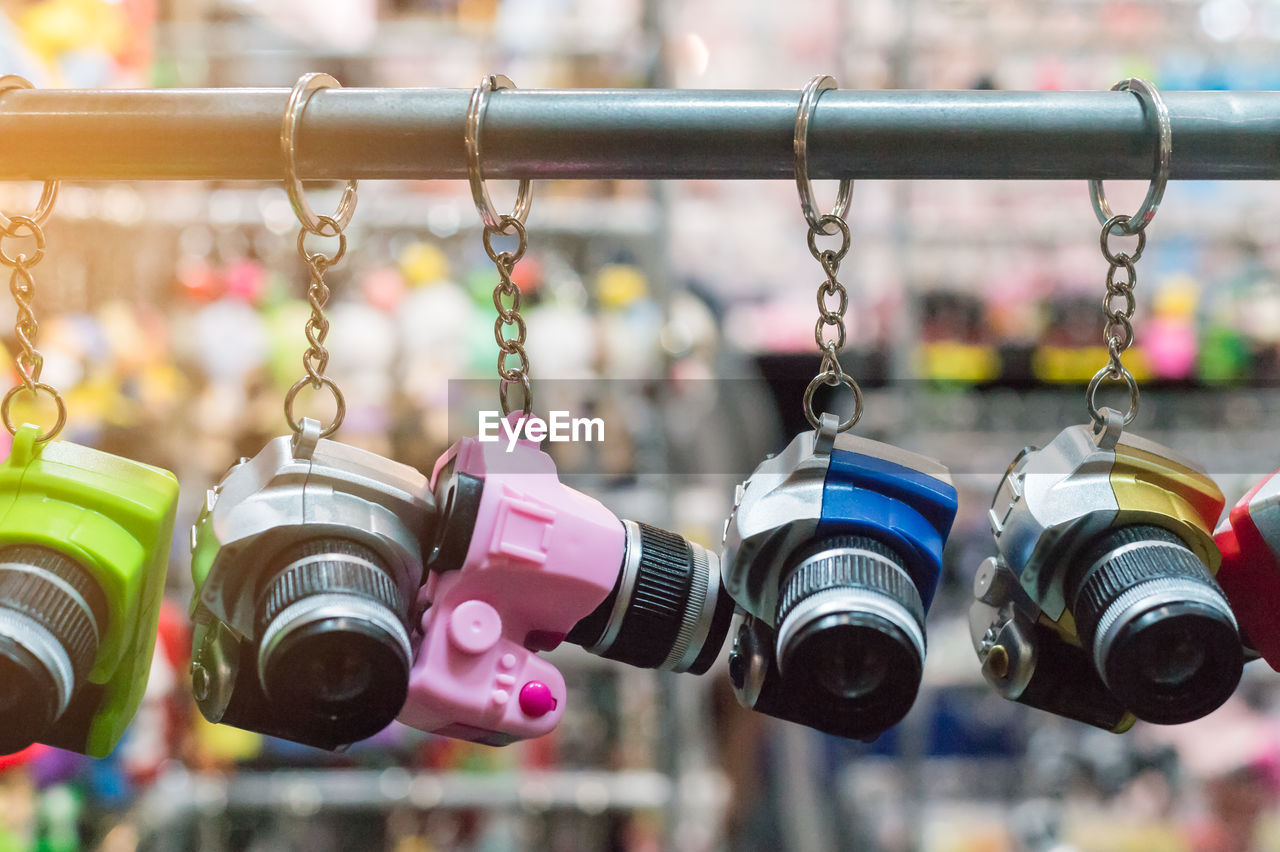 Close-up of camera key rings hanging for sale at market stall